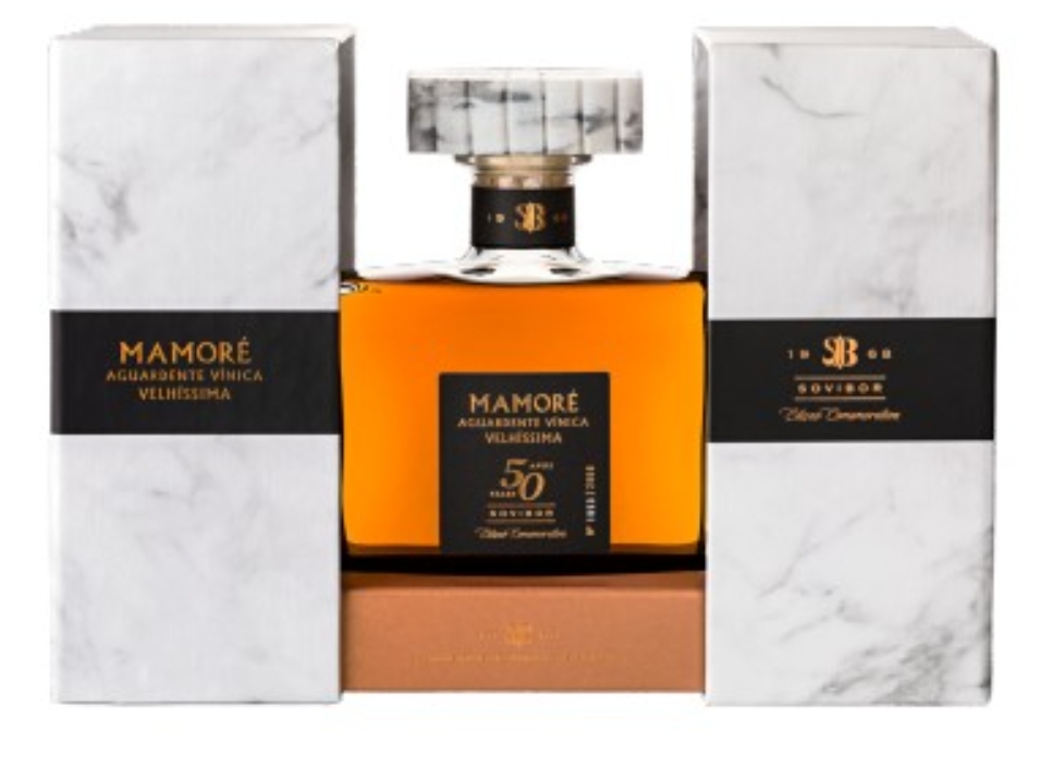 Frasco de aguardente Mamoré entre caixas brancas com padrão de mármore