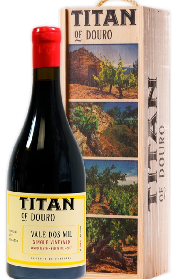 Garrafa de vinho tinto com rótulo amarelo e caixa de madeira com imagens de vinhas