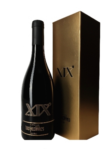 Garrafa de vinho tinto com rótulo preto e dourado ao lado de caixa dourada