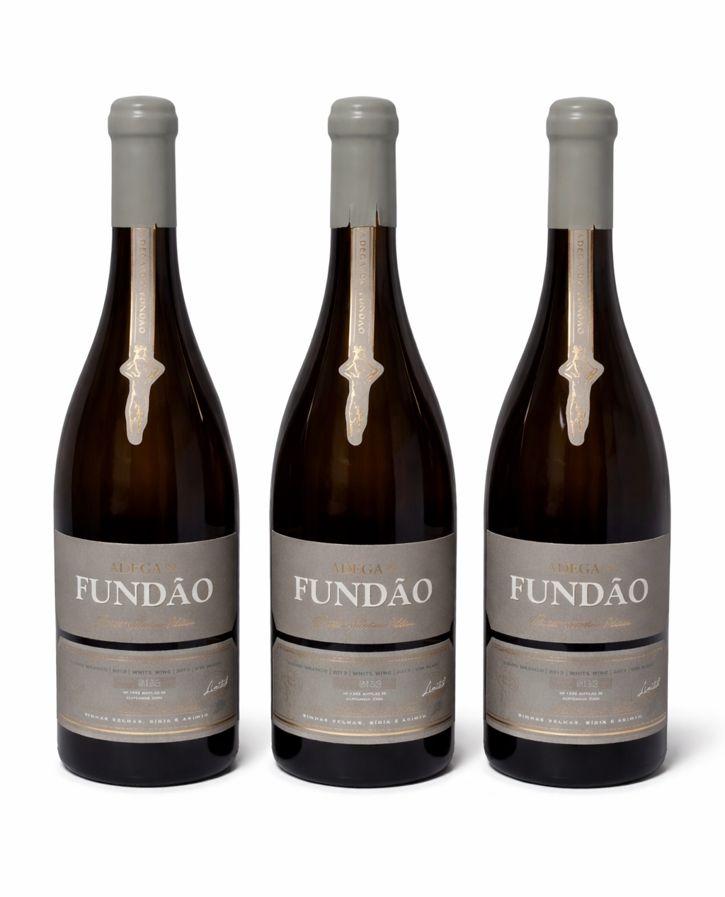 Três garrafas de vinho Adega do Fundão com rótulos cinza e selo dourado