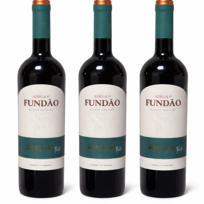 Três garrafas de vinho Adega Fundão com rótulo branco e verde-azulado e tampa verde com topo cobre