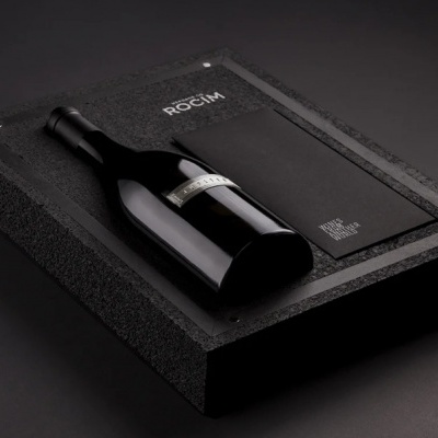 Garrafa de vinho tinto em caixa preta com envelope