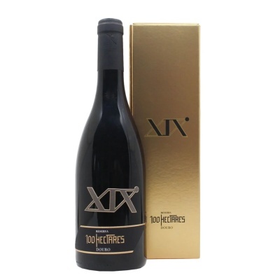Garrafa de vinho tinto com rótulo preto e dourado ao lado de caixa dourada.