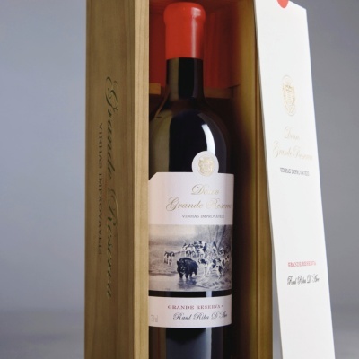 Garrafa de vinho tinto Deluxe Grande Reserva dentro de caixa de madeira aberta