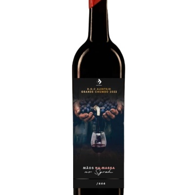 Garrafa de vinho tinto com rótulo preto e cera vermelha no gargalo