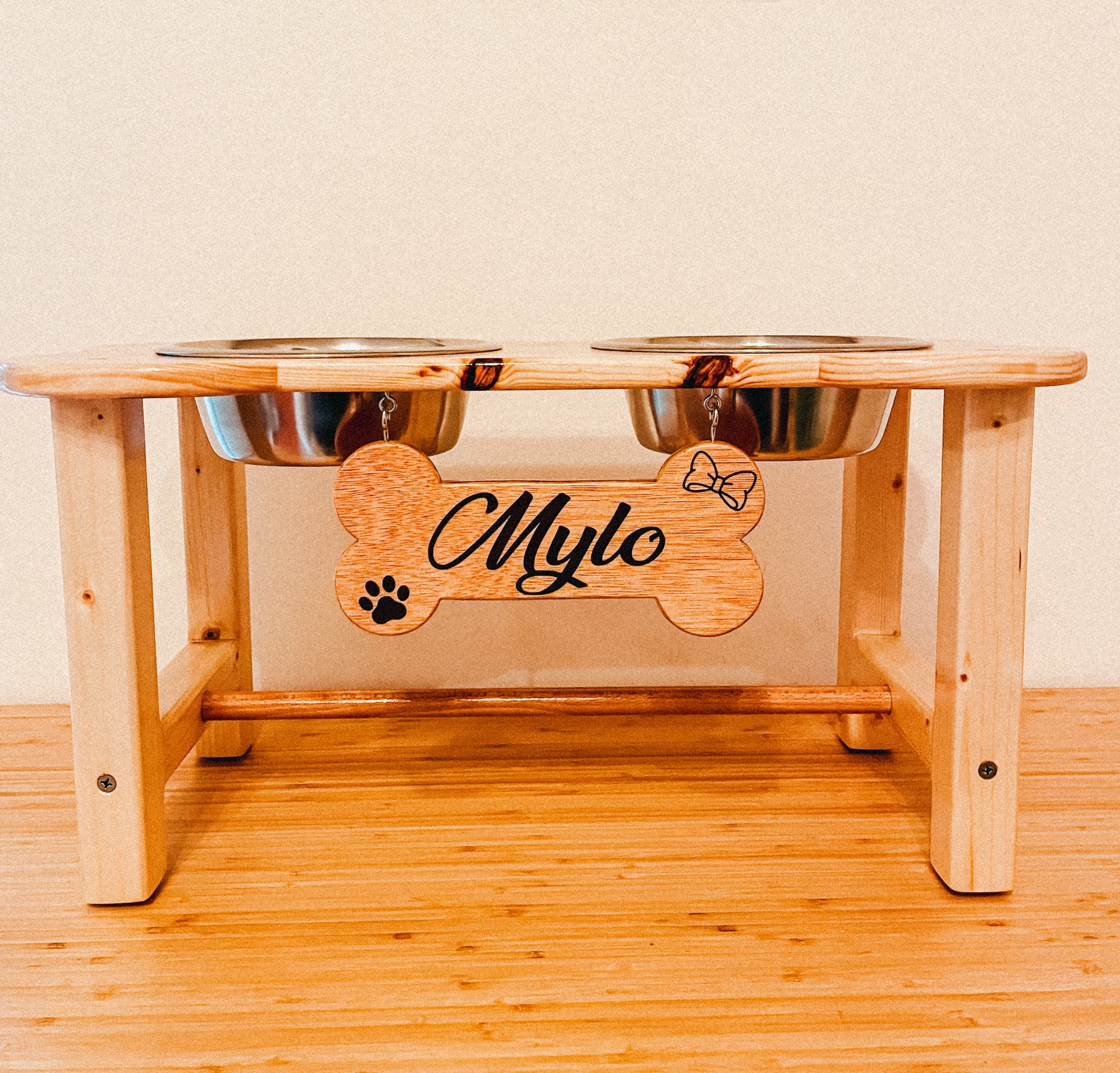 Comedouro elevado para cães em madeira clara com recipientes de inox e placa decorativa 'Mylo'