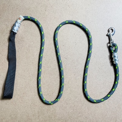 Trela para cão em corda preta com detalhes verdes e amarelos e gancho metálico