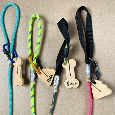 Cinco trelas para animais com cabos coloridos e etiquetas de madeira em forma de ossos com nomes