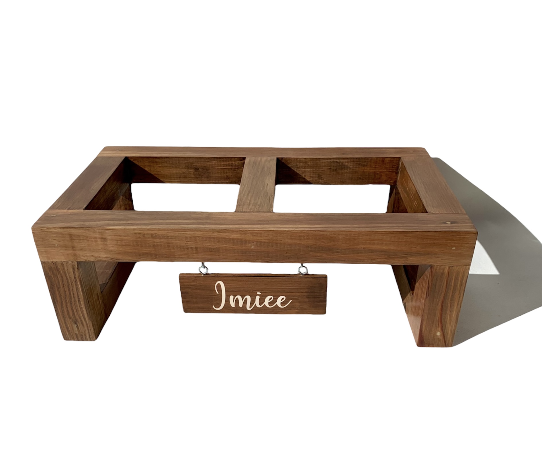 Suporte retangular em madeira castanha com placa pendurada com o texto 'Imiee'
