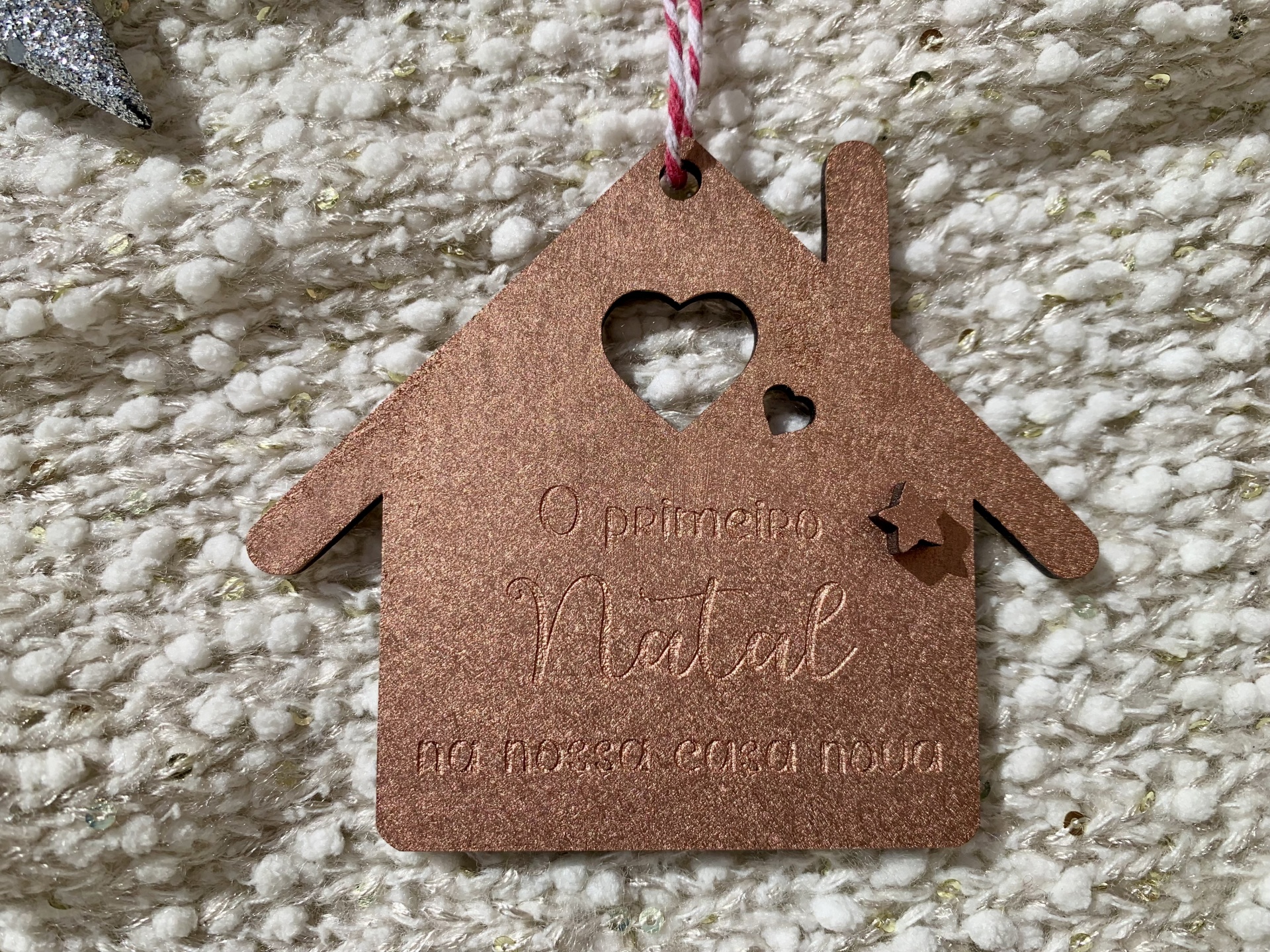 Enfeite de Natal em forma de casa de madeira castanha com recortes de coração e estrela