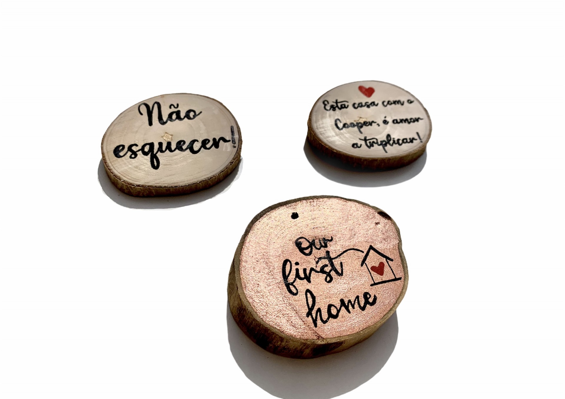 Pequenos pedaços de madeira com textos manuscritos e desenhos em fundo branco.