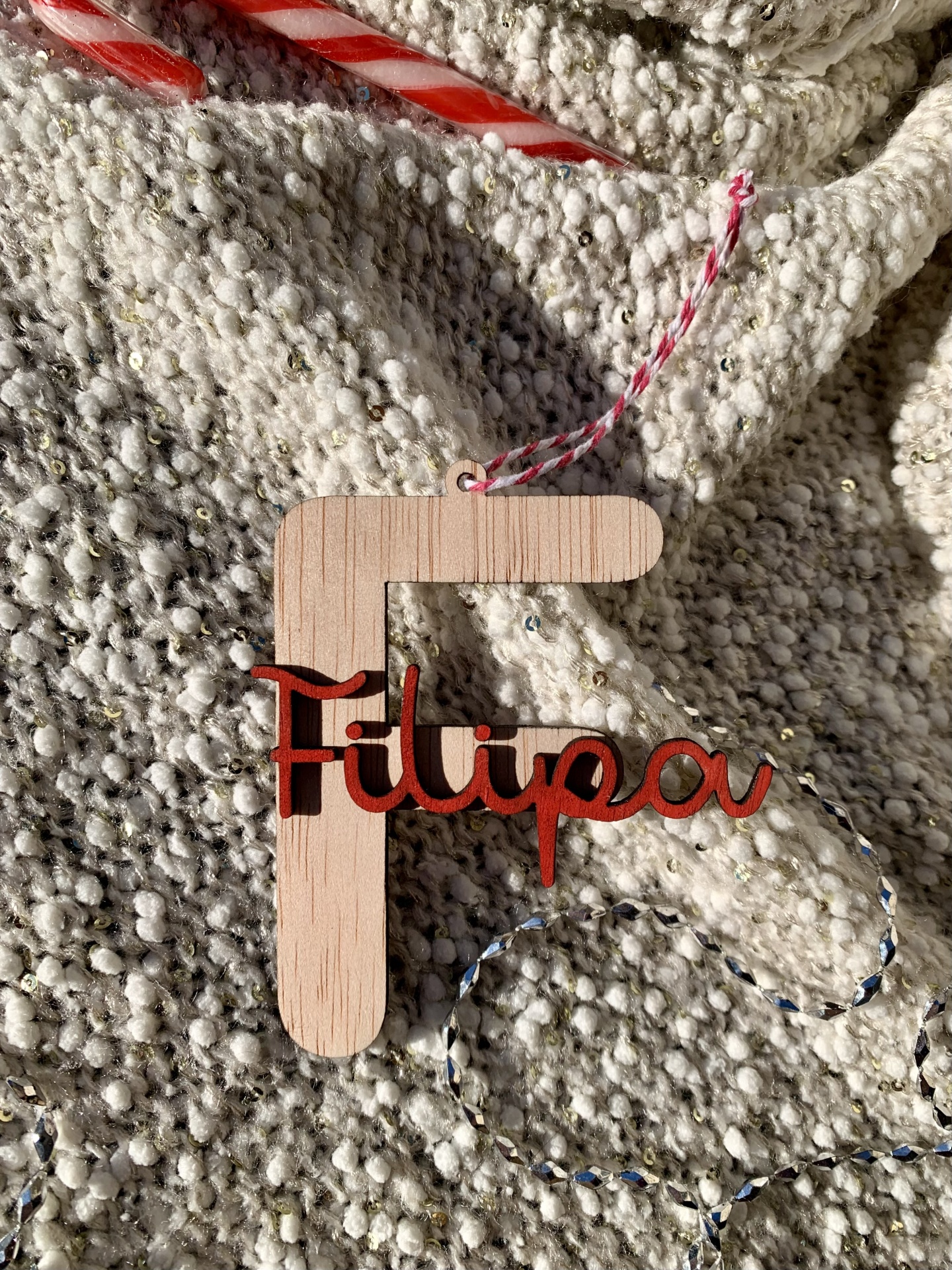 Ornamento de madeira com nome Filipa sobre tecido cinza texturizado