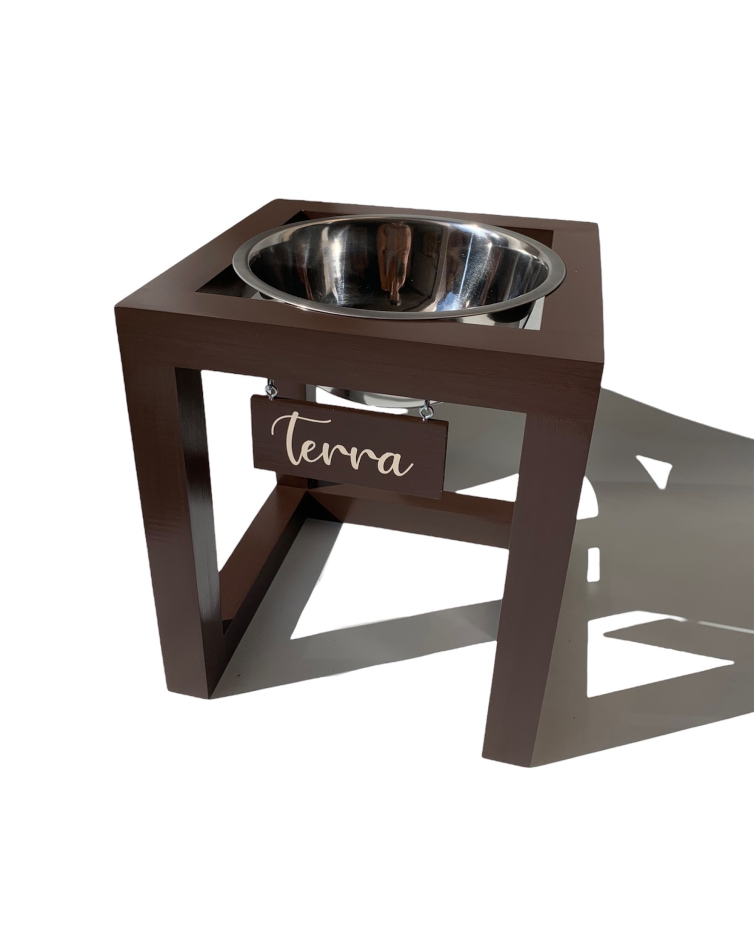 Comedouro elevado de madeira com tigela de aço inox e placa com texto 'terra'.