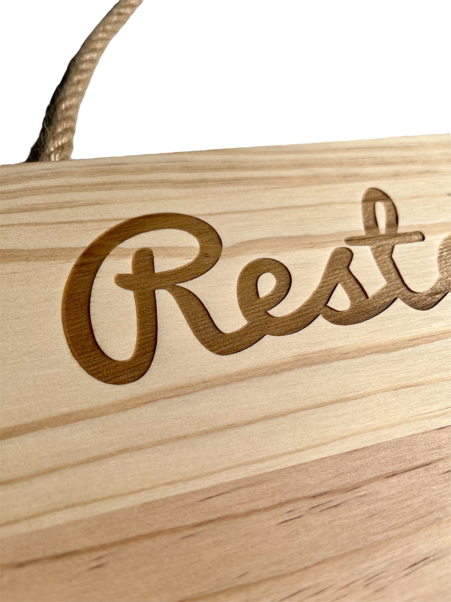 Placa de madeira clara com gravação 'Rest' e corda para pendurar