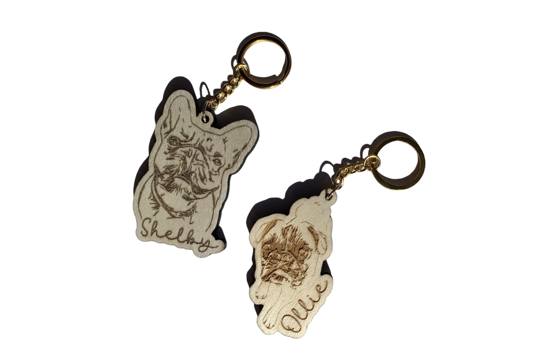 Dois porta-chaves com desenhos de cães e texto 'Shelby' e 'Quee'