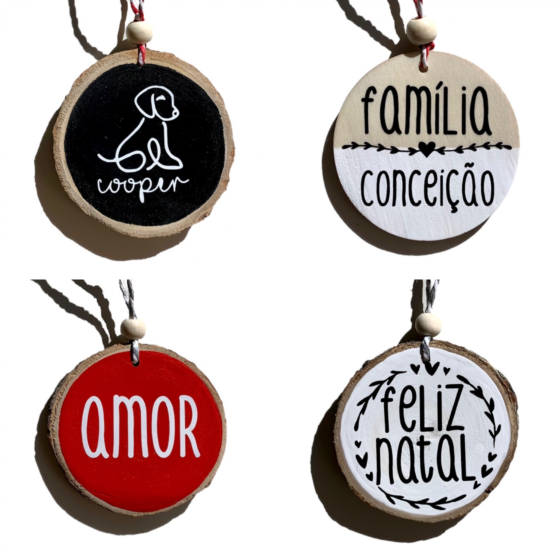 Quatro ornamentos circulares de madeira com texto e desenhos em diferentes cores e estilos.