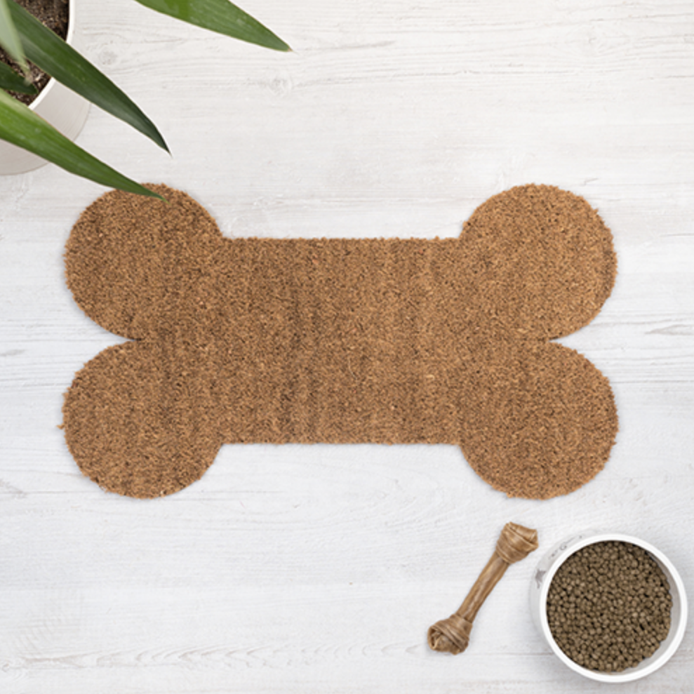 Tapete em forma de osso com pote de ração e osso de corda ao lado
