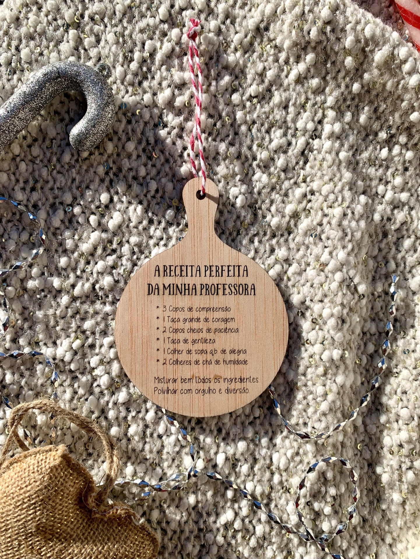 Etiqueta de madeira com receita em português sobre tapete cinza felpudo