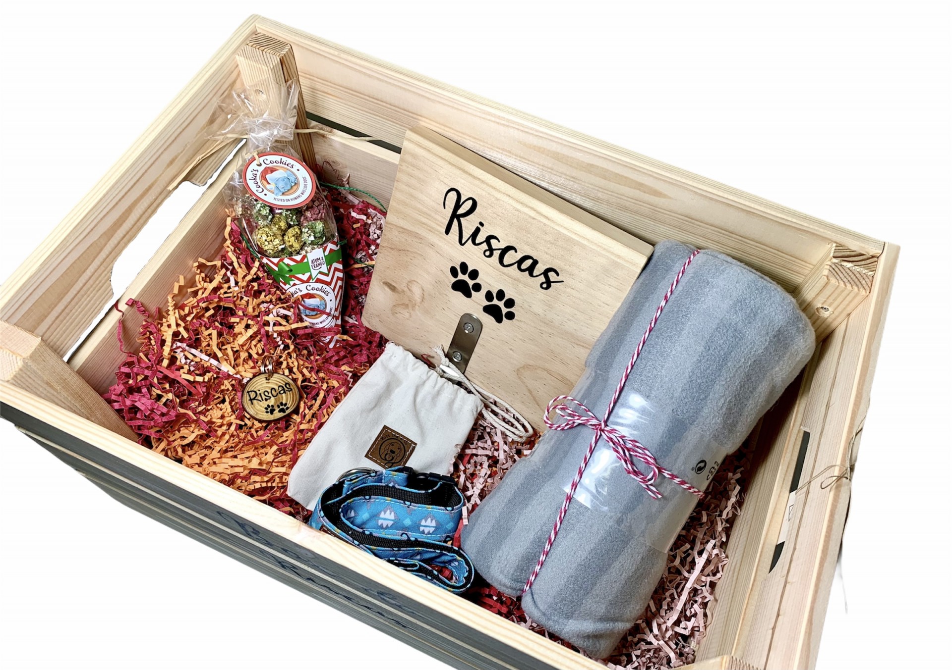 Caixa de presente madeira com linguiça, tábua de madeira, rolo de tecido cinza e sacos de tecido em papel colorido