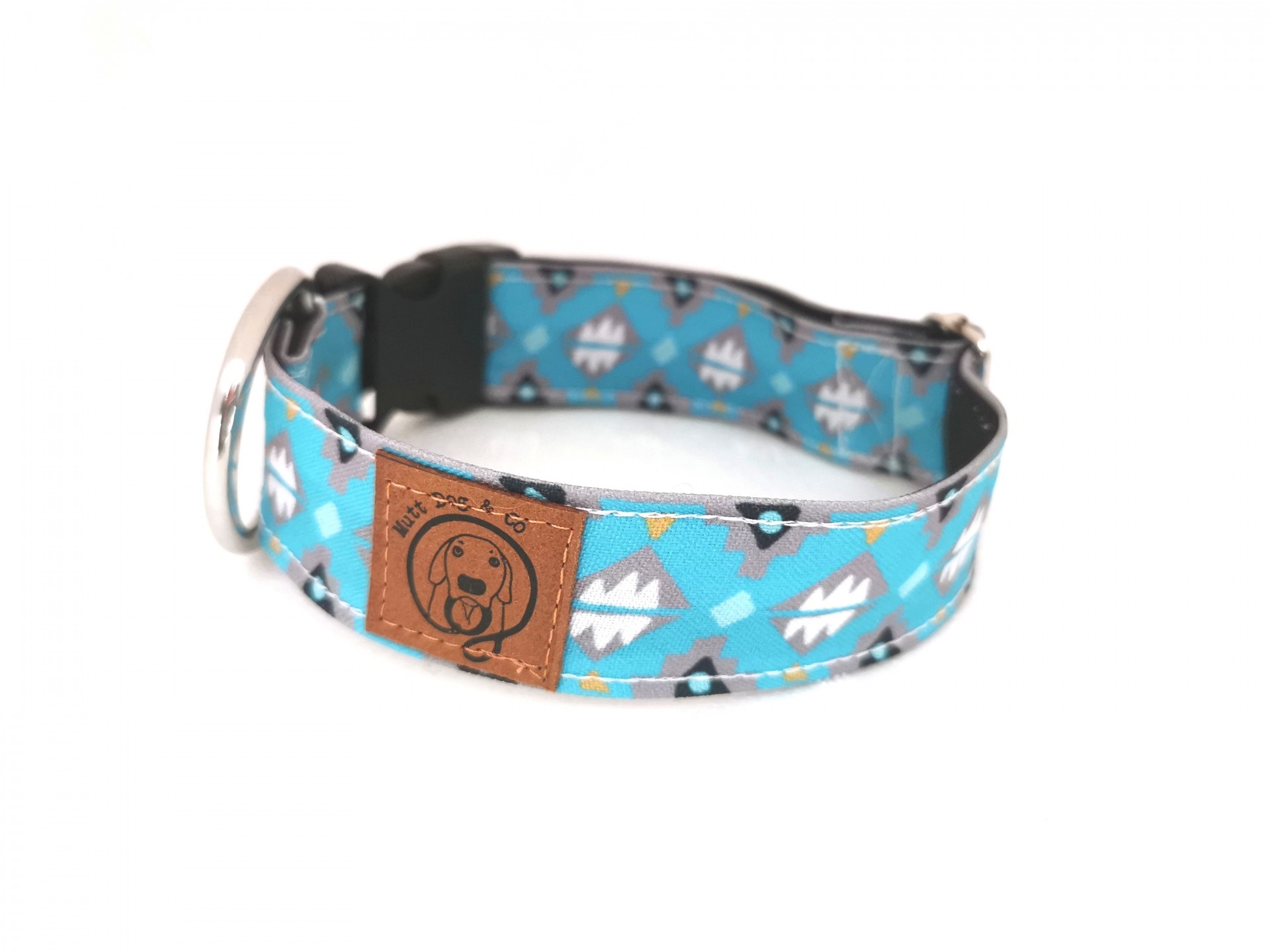Coleira azul para cão com padrão geométrico e etiqueta castanha com imagem de cão