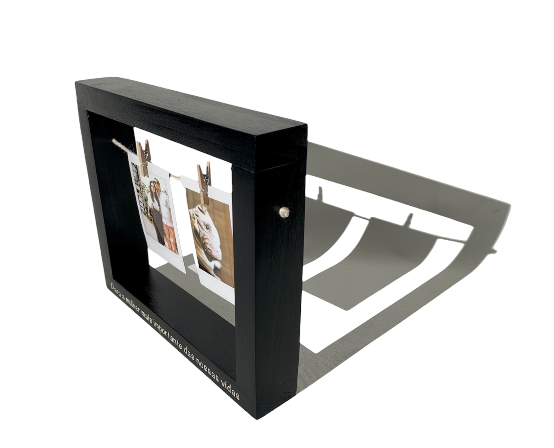 Estrutura de madeira preta quadrada com fotografias penduradas em varas metálicas