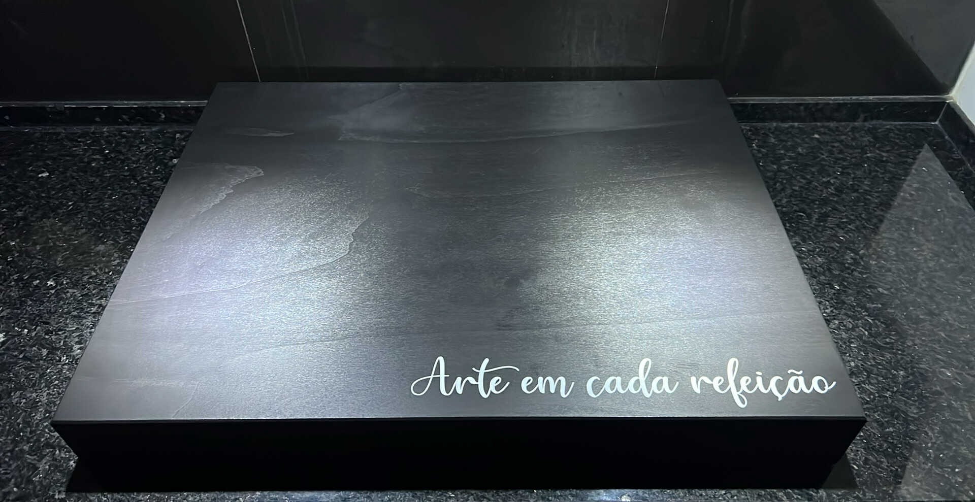 Caixa preta com texto branco 'Arte em cada refeição'