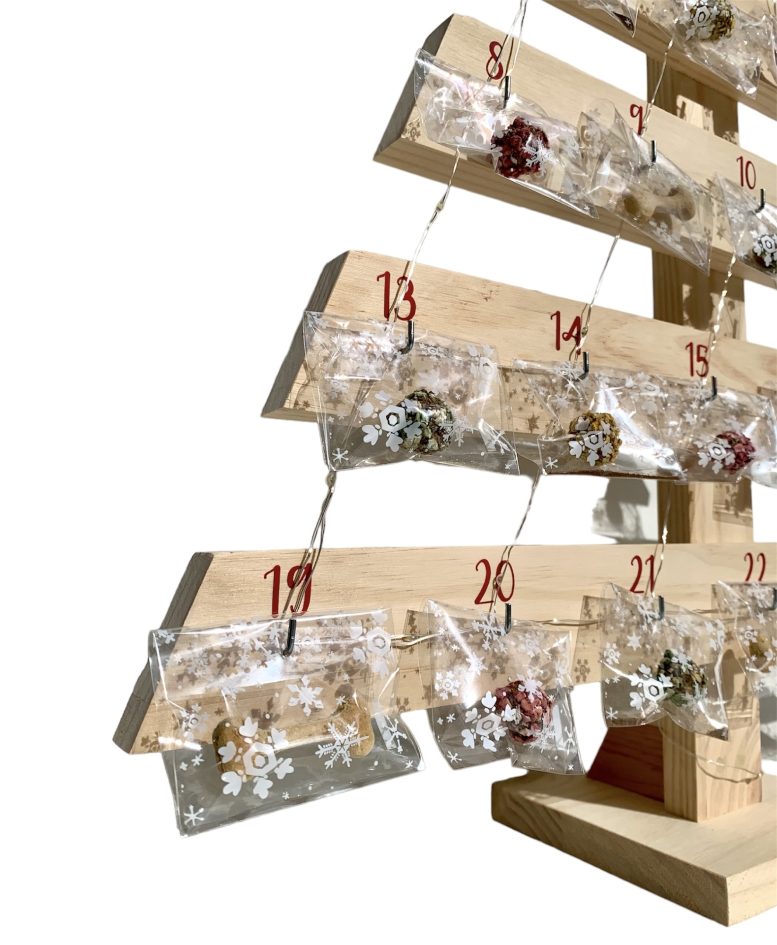 Árvore de madeira com saquinhos plásticos numerados decorados com flocos de neve, calendário do advento