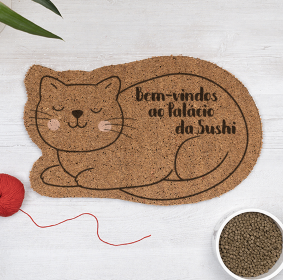 Tapete de cortiça em forma de gato com texto de boas-vindas em português.