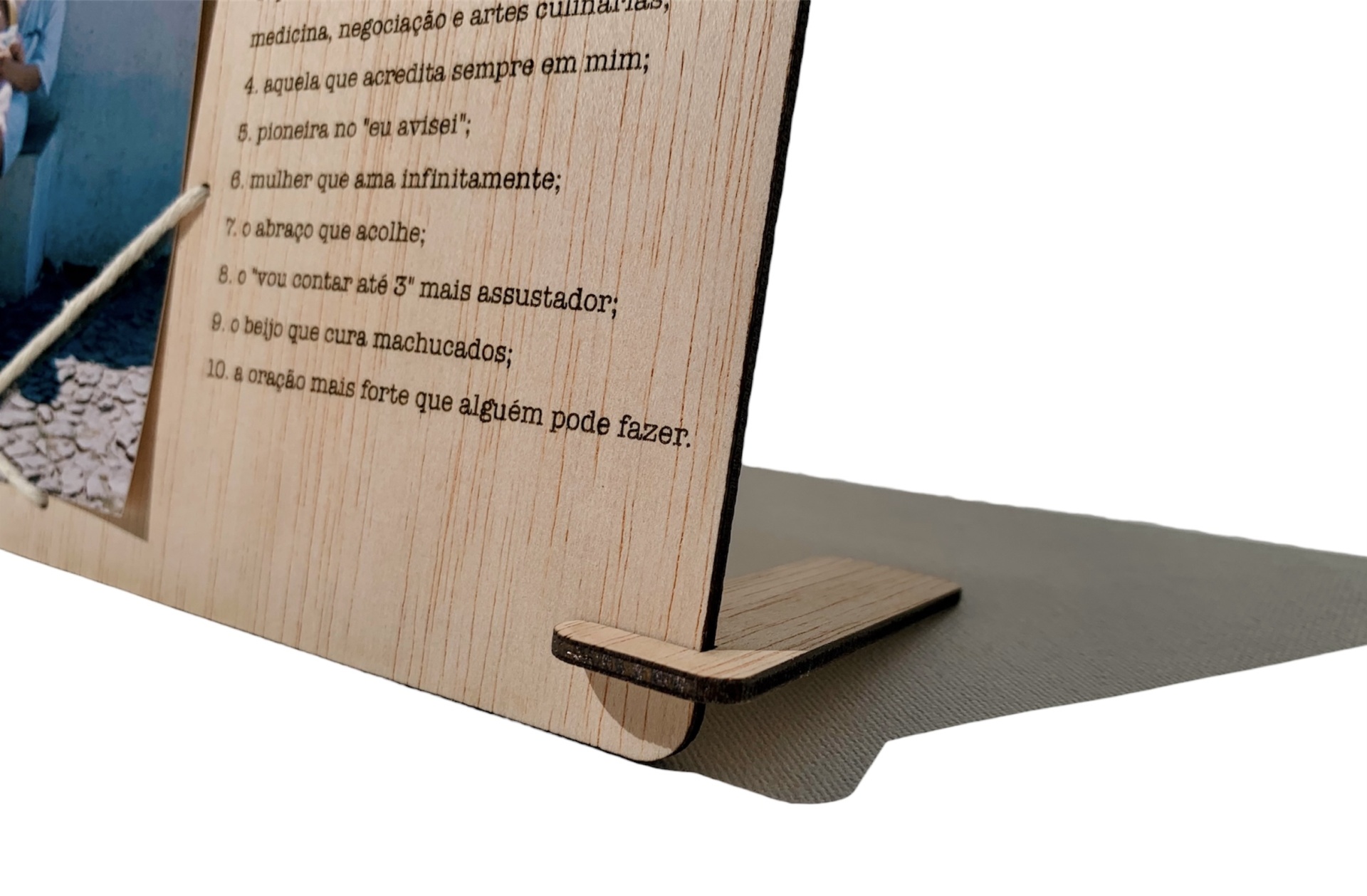 Objeto em madeira com texto impresso em português numa superfície plana cinzenta