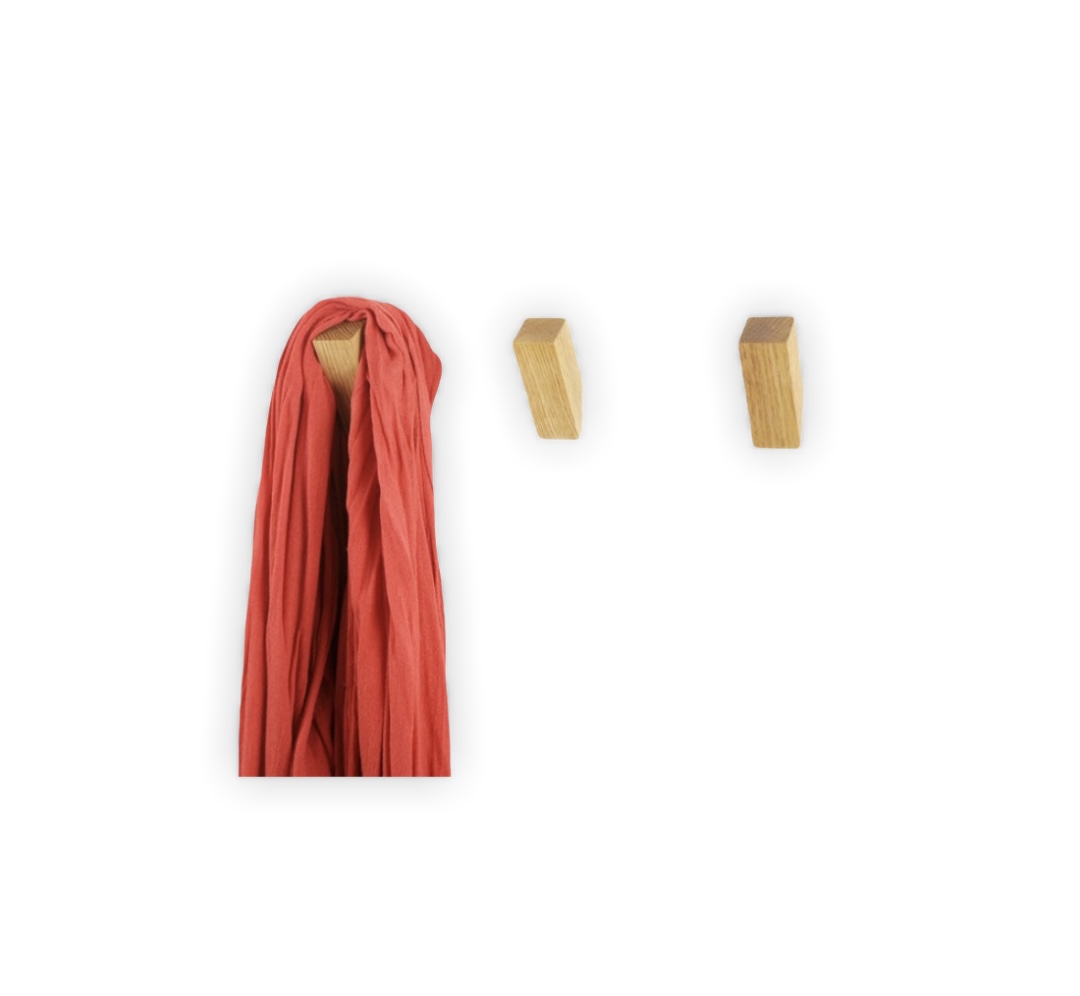 Três cabides de parede em madeira clara, um com lenço vermelho