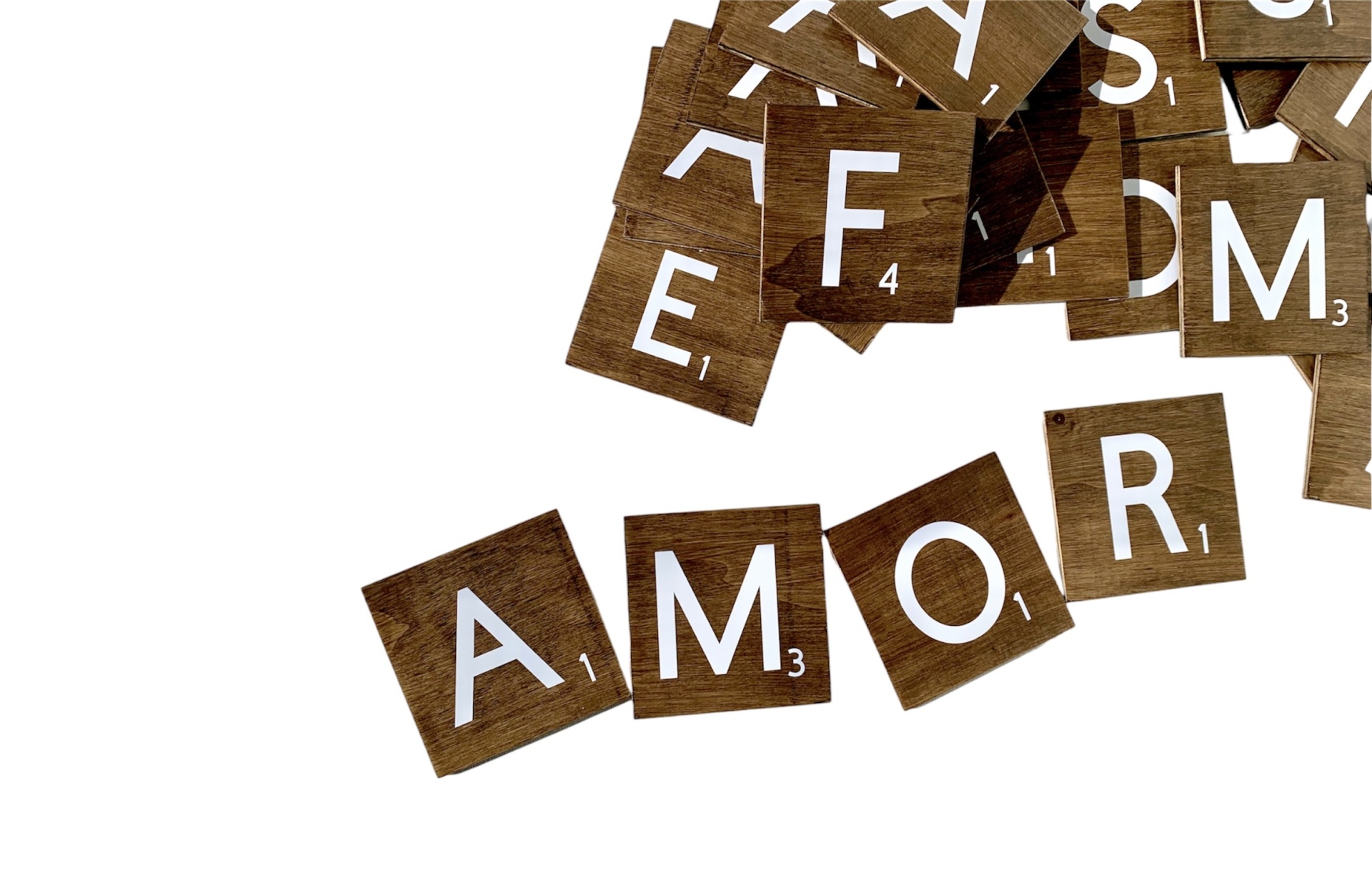 Letras de madeira com letras brancas formando a palavra AMOR e outras letras soltas