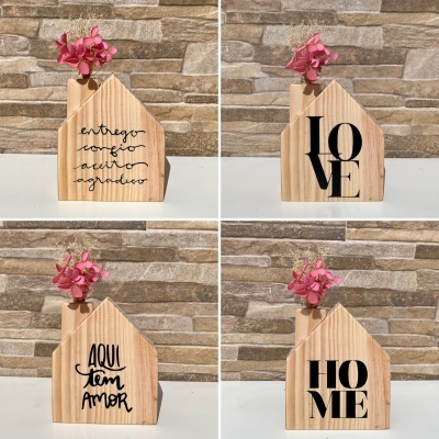 Vasos decorativos em madeira clara com flores rosas e inscrições em preto