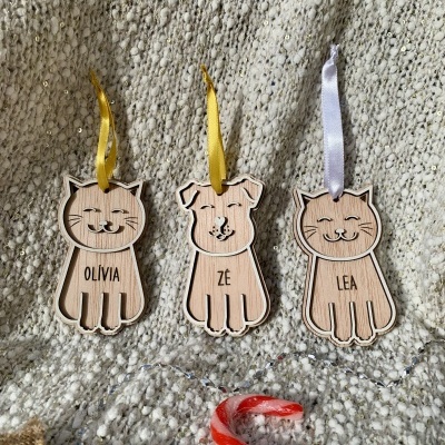 Ornamentos de madeira com formas de animais e fitas para pendurar sobre manta texturada