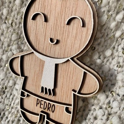 enfeite de Natal em forma de boneco de madeira e cortiça com a palavra PEDRO