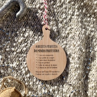 Etiqueta de madeira com receita em português sobre tapete cinza felpudo