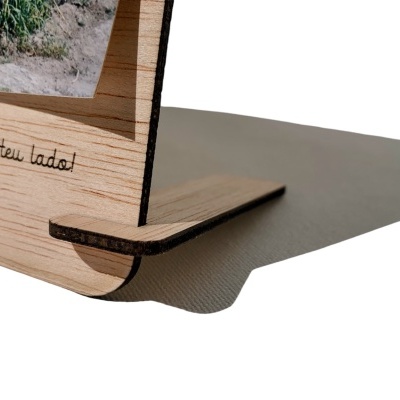 Suporte de madeira com gravação em português num fundo branco.