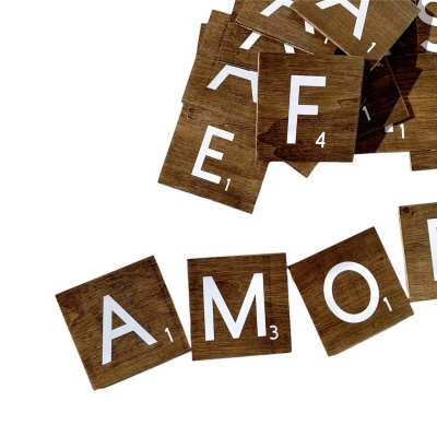 Letras de madeira com letras brancas formando a palavra AMOR e outras letras soltas