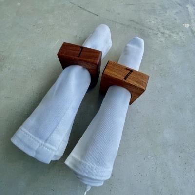 Guardanapos brancos com argolas de madeira castanha sobre superfície cinzenta