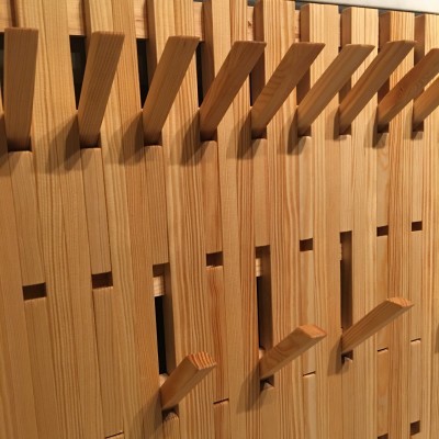 Cabide de parede em madeira clara com ganchos inclinados