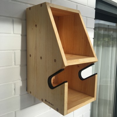 Prateleira de parede em madeira clara com dois compartimentos e suporte preto, montada em parede branca.