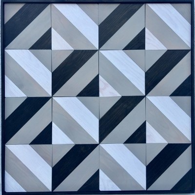 Painel decorativo quadrado com padrão geométrico em madeira colorida