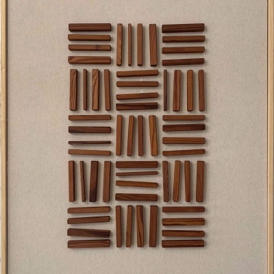 Quadro decorativo com ripas de madeira castanhas em padrão geométrico sobre fundo bege.