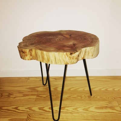 Mesa lateral em madeira clara com três pés metálicos pretos