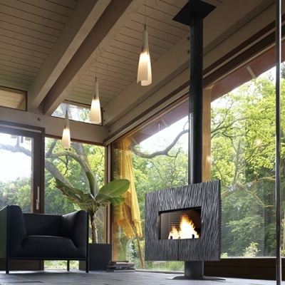 Lareira suspensa em metal preto com textura ondulada e fogo aceso numa sala moderna com janelas grandes