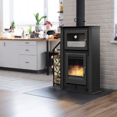 Lareira preta a arder numa cozinha moderna com armários brancos e bancada de madeira