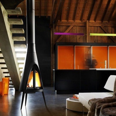 Lareira preta moderna numa sala com cozinha e sofá branco.