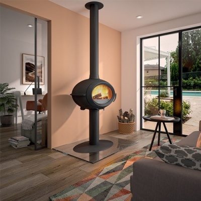 Lareira suspensa redonda em metal preto com vidro frontal e fogo aceso numa sala moderna