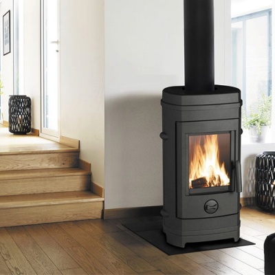 Lareira a lenha preta com fogo, em sala com chão e escadas de madeira clara