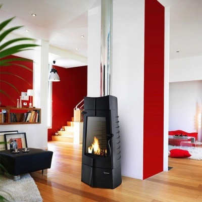 Lareira moderna preta com chaminé metálica em sala com paredes branca e vermelha