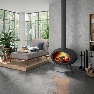 Lareira preta oval moderna numa sala minimalista com poltrona cinza e plantas